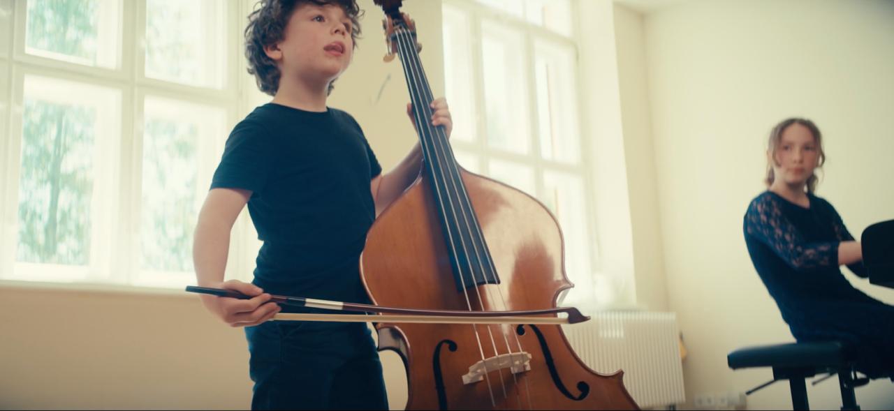 Child playing small double bass